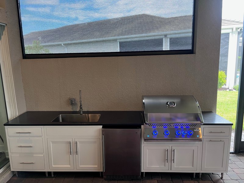 Compact outdoor kitchen with a built-in grill and one side open.